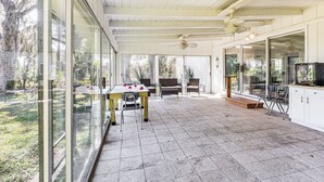 A covered patio area with a pool table, seating, and a television. - 10 Mi to St Simons Island: Home w/ Screened Porch (Brunswick)