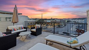 A rooftop terrace with outdoor seating, a view of the cityscape, and a sunset. - Bend in the River - Gorgeous 4-Level Brownstone with Rooftop Views (Georgetown)