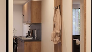 Une cuisine moderne avec des meubles en bois, un îlot central intégré et un porte-serviettes suspendu.