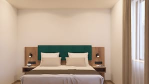 Une chambre à coucher moderne avec une tête de lit recouverte d’un tissu vert, deux tables de chevet avec des lampes et une grande fenêtre avec des rideaux.