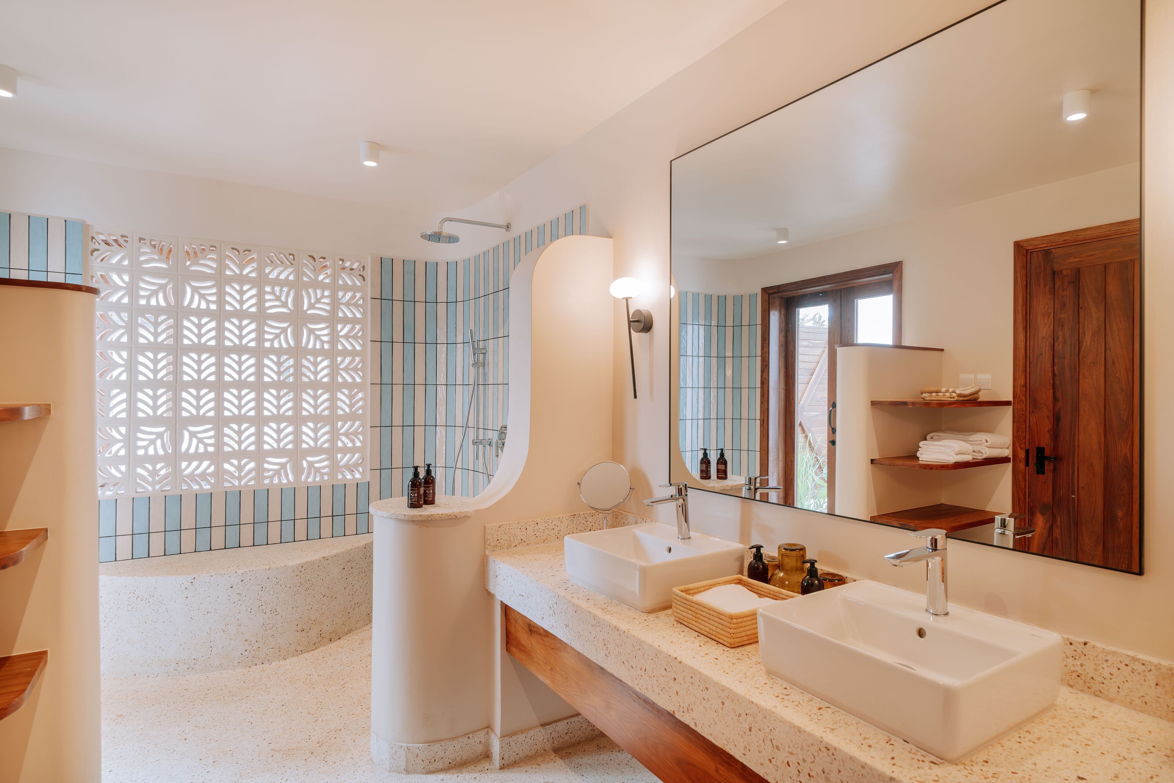 Ein modernes Badezimmer mit einer freistehenden Badewanne, zwei Waschbecken, einem großen Spiegel und einer Holzwaschkommode.