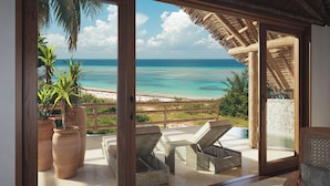 A room with a sliding glass door leading to a balcony with a view of the ocean and beach. - Matemwe Attitude (Matemwe)