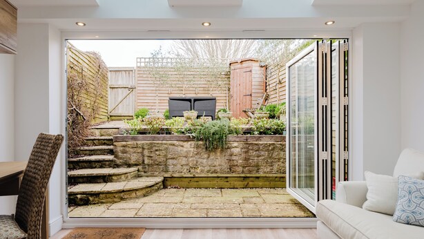 A modern interior space with a glass door leading to a stone staircase and a garden. - Stylish Retreat with Garden in Tetbury (Tetbury)