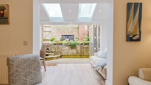 A modern living room with a view of a garden and a patio area. - Stylish Retreat with Garden in Tetbury (Tetbury)