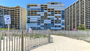 A beachfront property with a sign indicating 'Leave Only Your Footprints Please' and 'Dune Crossing'. - HPN-1 Bedroom Oceanfront Condo, Steps to the Beach! (Ocean City)