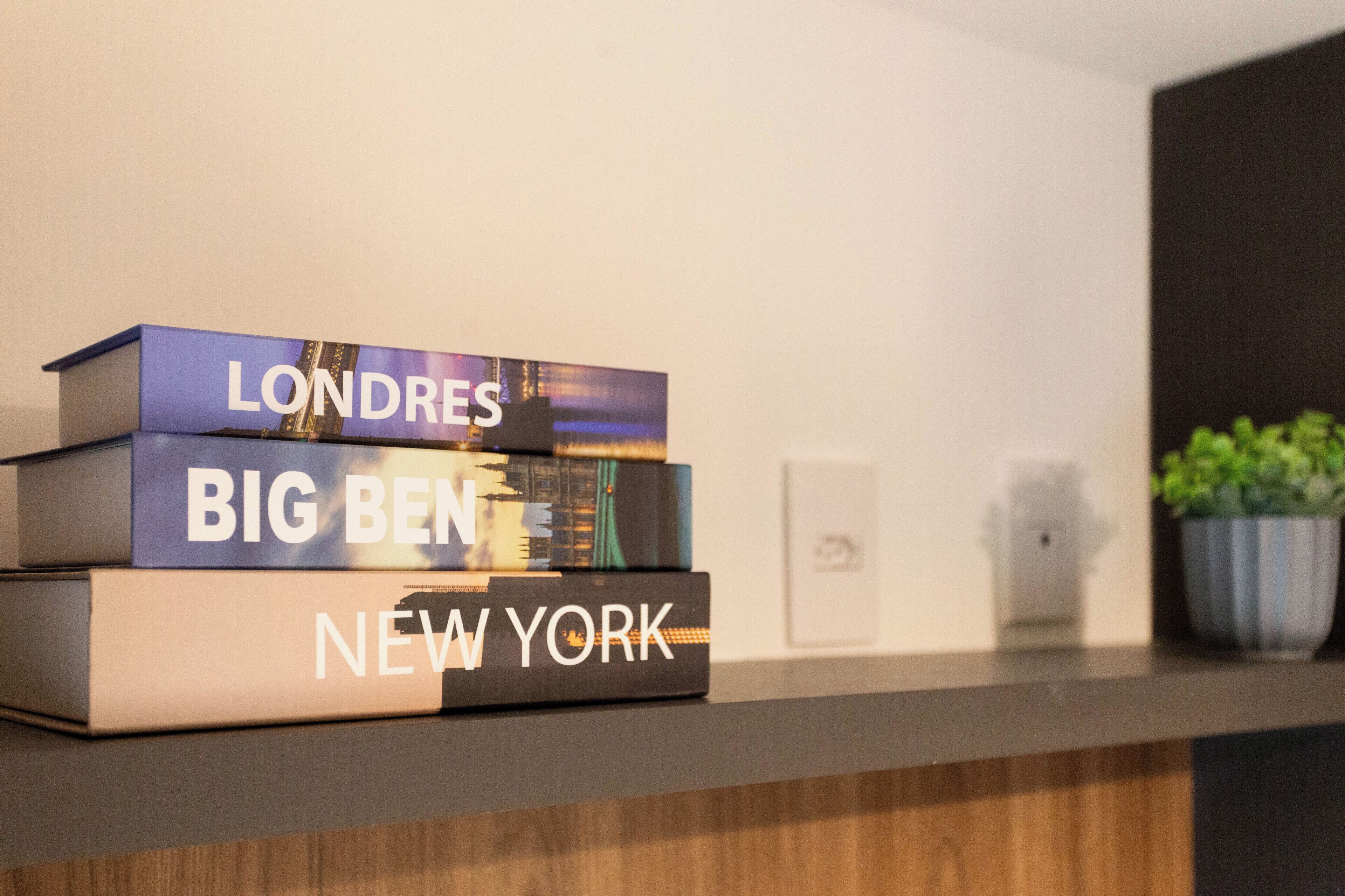 A stack of books titled 'Londres', 'Big Ben', and 'New York' on a shelf.