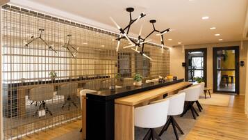Una cocina moderna con una isla central, asientos tipo bar y un separador metálico decorativo.
