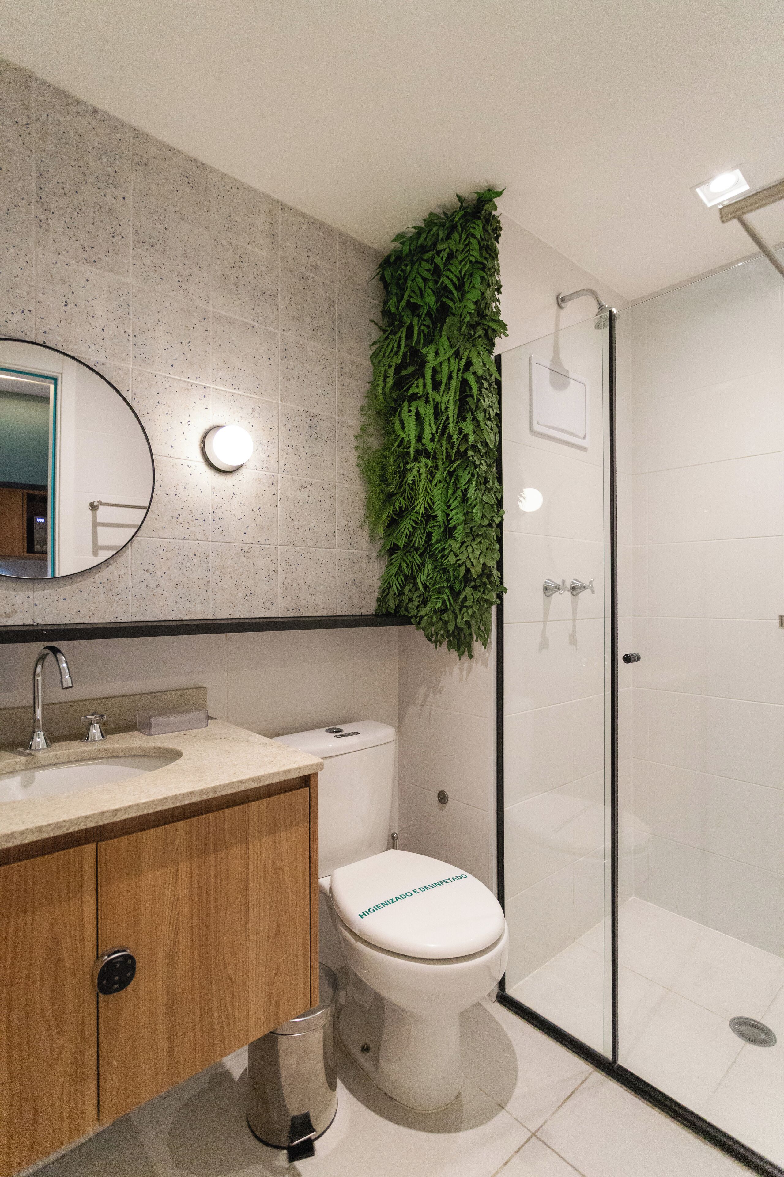 A modern bathroom with a toilet, sink, and shower.