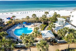 A resort with a swimming pool, beach, and palm trees. - Sterling Shores 902 3 Bedroom Condo (Destin)