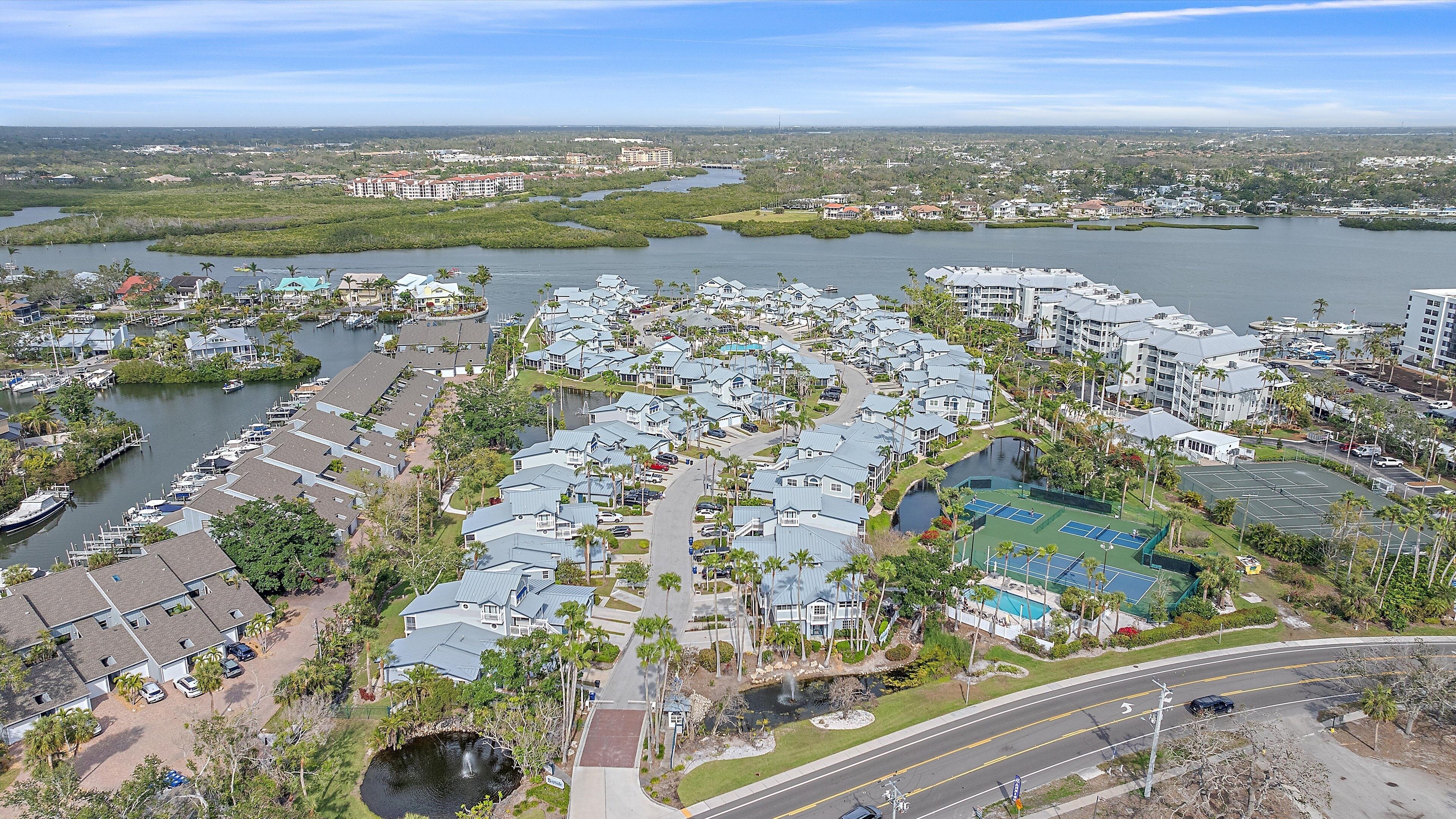 A residential area with houses, a marina, and a large body of water.