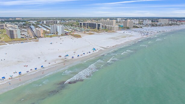 Ein Strand mit mehreren Hotels im Hintergrund.