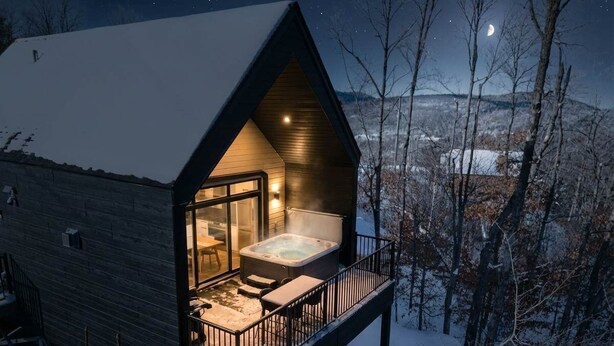 A cozy cabin with a hot tub on the deck, surrounded by snow and trees. - Spa | Mountain | Modern Comfort | Elska (Saint-Côme)