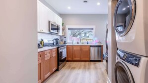 Une cuisine moderne avec des meubles en bois, un lave-vaisselle en acier inoxydable et un four encastré.