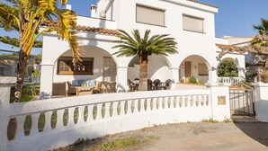 A white building with a tiled roof, arched doorways, and a gated entrance. - Holiday Home 'Deltabahia' with Shared Pool, Wi-Fi and Air Conditioning (Alcanar)