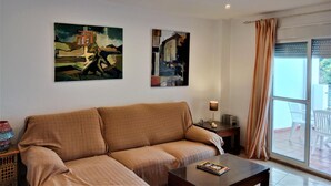 A living room with a sofa, a coffee table, and two abstract paintings on the wall. - Rotonda I 88 in Conil de la Frontera (Conil de la Frontera)