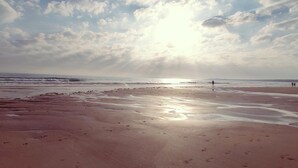 A beach with wet sand and footprints, a clear sky, and the sun shining. - Rotonda I 88 in Conil de la Frontera (Conil de la Frontera)