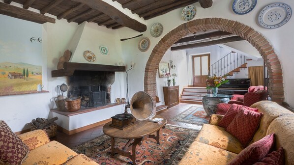 A traditional living room with a fireplace, patterned rugs, and rustic decor.