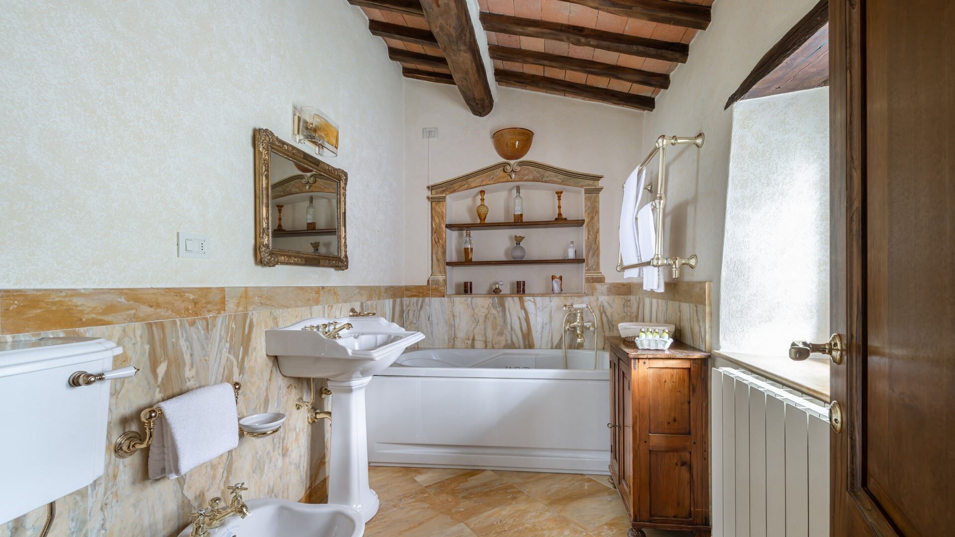 Un baño con bañera, dos lavamanos, tocador y espejo.