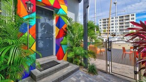 A colorful building with a geometric facade, a door with the number 2, and a balcony with chairs. - Orange Dream on the Water (Fort Lauderdale)