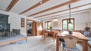 A cozy room with a wooden dining table, bench seating, and a built-in bench with cushions. - Modern farmhouse for 10 people (Nesselwang)