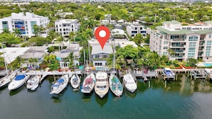 A marina with several boats docked, surrounded by buildings and greenery.