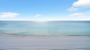 Una playa con cielo despejado y mar tranquilo.
