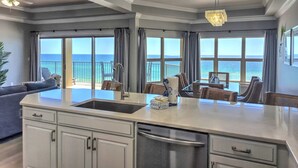 Una cocina moderna con una isla grande, un comedor y vistas al océano.