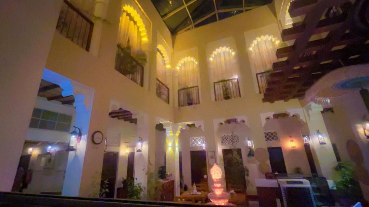 Ein mehrgeschossiges Atrium mit einer zentralen Treppe, dekorativer Beleuchtung und einem Chandelier.