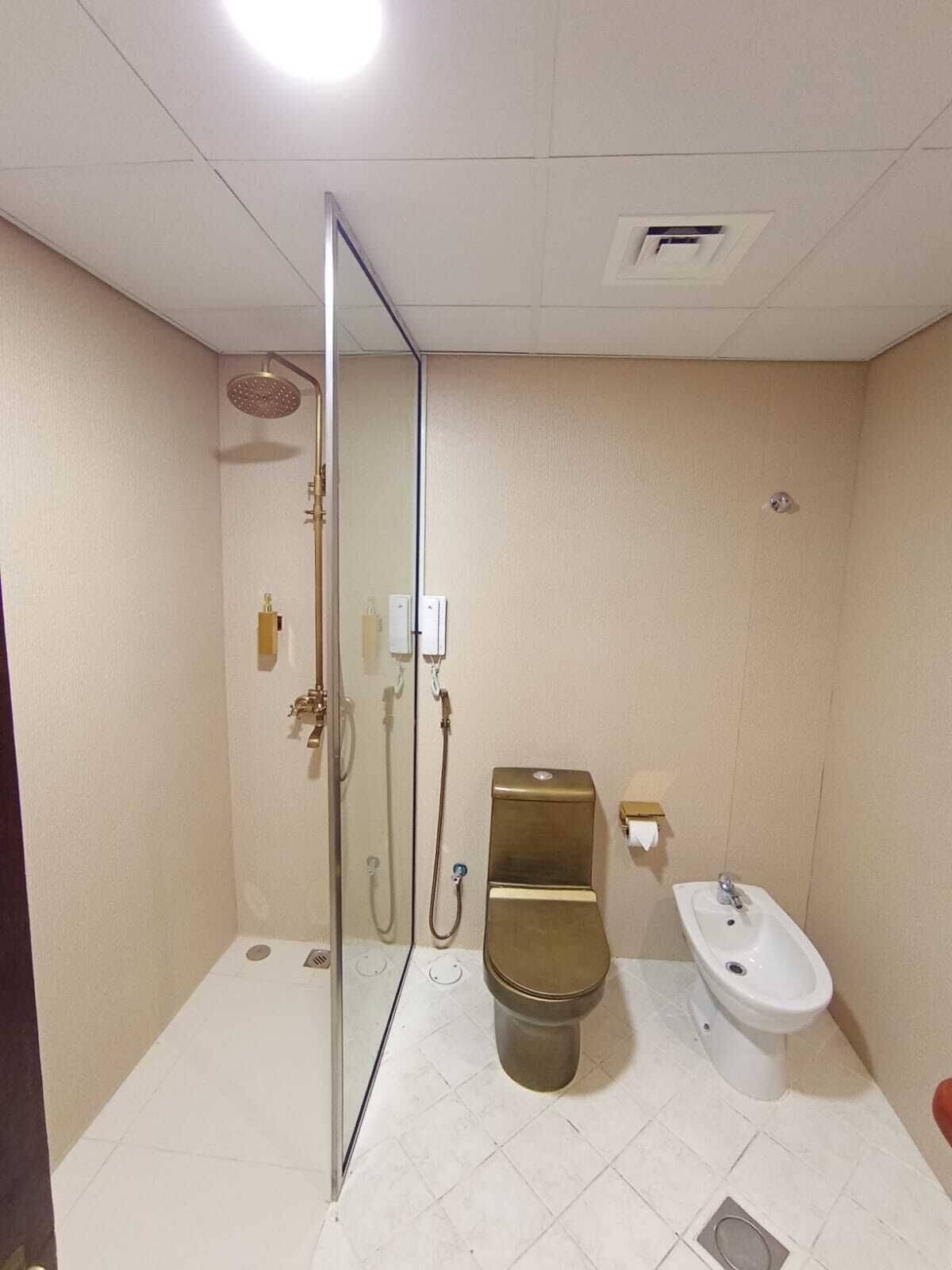 A small, compact bathroom with a toilet, bidet, and shower.