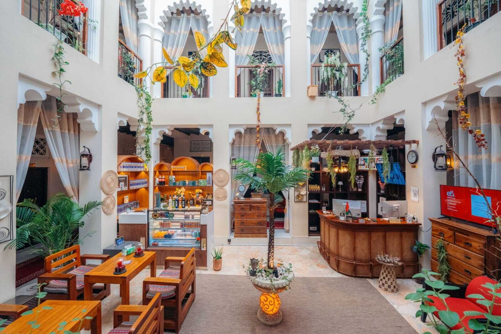 Ein großzügiger Innenhof mit Café, Sitzgelegenheiten und einer Rezeption.
