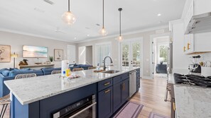 A modern kitchen with a central island, pendant lighting, and a view to the outdoors. - CURRENTLY DISCOUNTED!Home w/ Private Pool, Golf Cart & Bikes!  - The Grand Mary (Santa Rosa Beach)