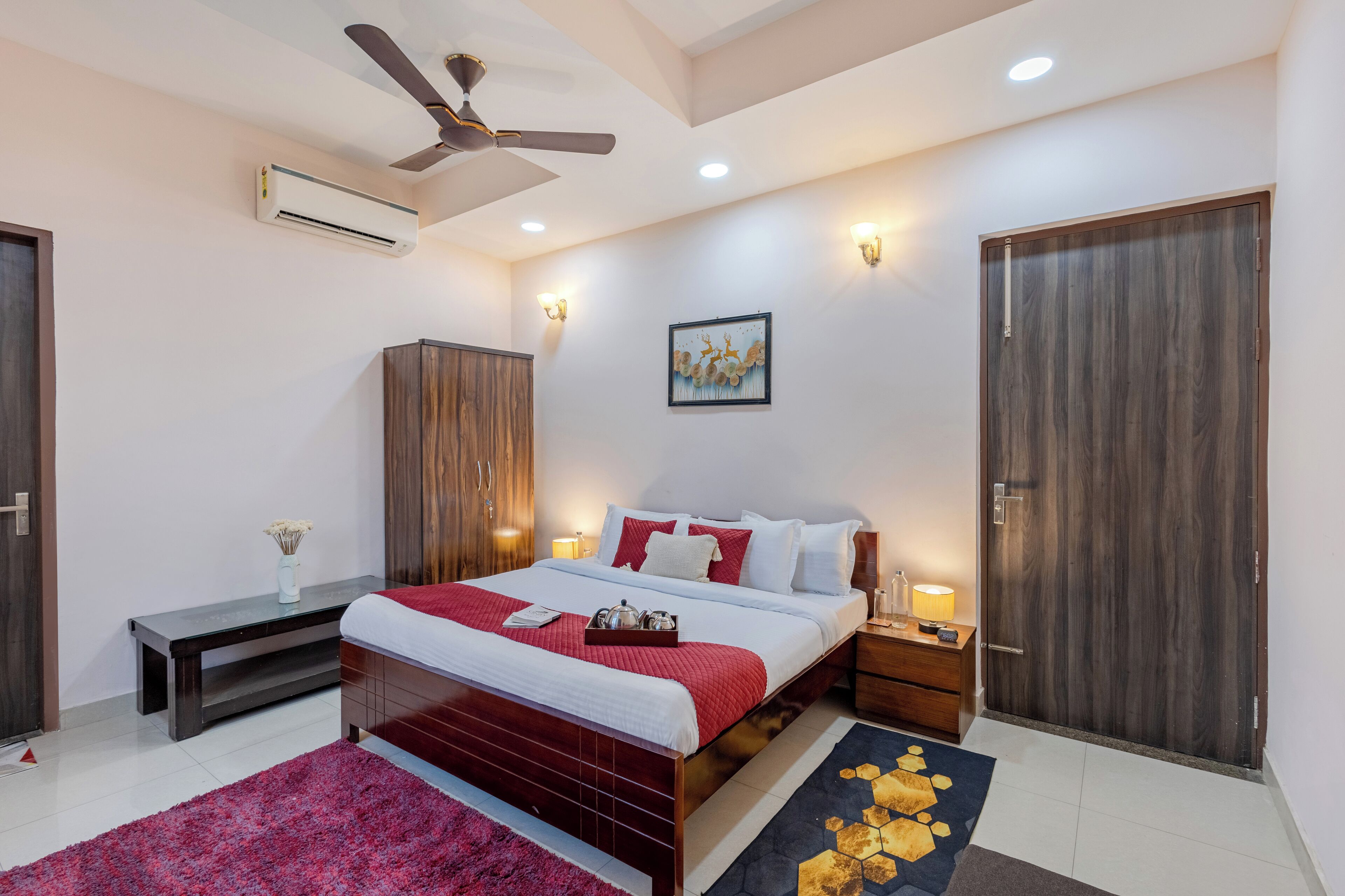 Quarto moderno com cama, mesas de cabeceira, guarda-roupa e ventoinha no teto.