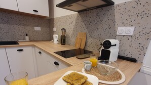 Une cuisine moderne équipée d’un plan de travail, d’une machine à café, d’un grille-pain et d’une assiette de biscuits.