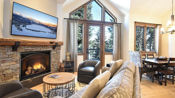 Una sala acogedora con chimenea, un ventanal grande y un espacio de descanso confortable.