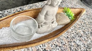 A Buddha statue on a wooden tray with a bowl of salt and a rock. - Cozy room in Remich (Remich)