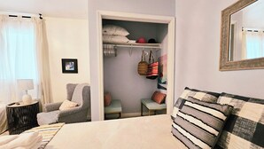 A bedroom with a bed, a chair, a bedside table, a wardrobe, and a mirror. - Blueberry Farm Views & Vineyards Nearby (Jonesville)