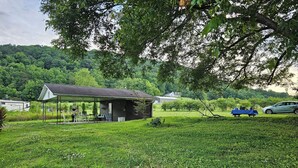 A small, rustic cabin with a covered porch and a table set up outside. - Blueberry Farm Views & Vineyards Nearby (Jonesville)