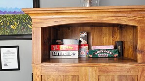 A wooden shelf with various board games and a framed certificate. - Blueberry Farm Views & Vineyards Nearby (Jonesville)