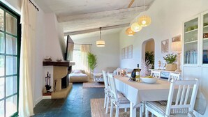 A spacious dining area with a long table, white chairs, and hanging pendant lights. - The Cliffs - Vue de Pantin (Valdoviño)