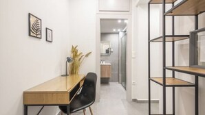A modern hallway with a desk, chair, and shelving unit. - Home in Athens (Kallithea)