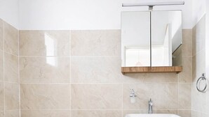 Ein modernes Badezimmer mit Toilette, Waschbecken und einem Spiegel darüber.