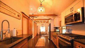 A kitchen with wooden cabinets, a stainless steel stove, and a microwave.