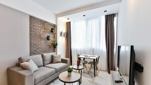 Una sala moderna con sofá, mesa de centro y comedor con mesa y sillas.
