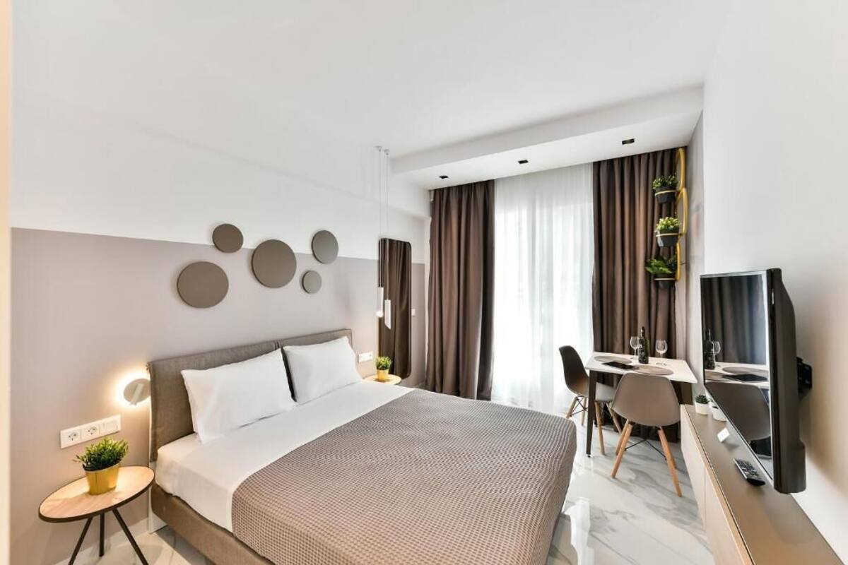 Une chambre d’hôtel moderne équipée d’un lit, d’une table de chevet et d’un bureau avec des chaises.