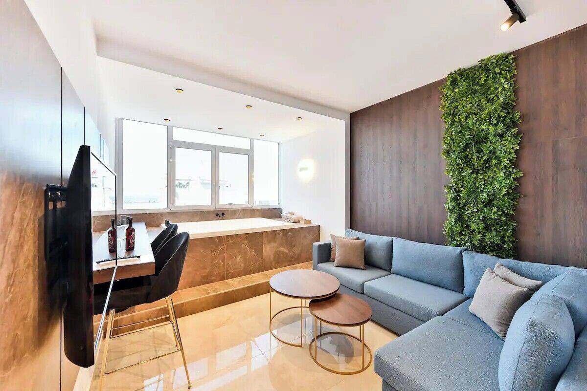 Un salon moderne avec un canapé, une table basse et un téléviseur fixé au mur.