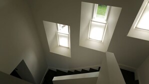 Una escalera con tragaluces que dejan entrar luz natural.