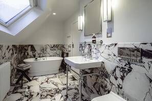A modern bathroom with a freestanding bathtub, a pedestal sink, and a large mirror. - Old School - cozy cottage for 7 (Aberdeenshire)