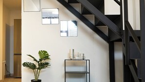 Eine moderne Treppe mit schwarzen Geländern, einem Topf mit Pflanze und einem kleinen Tisch mit Kerzen.