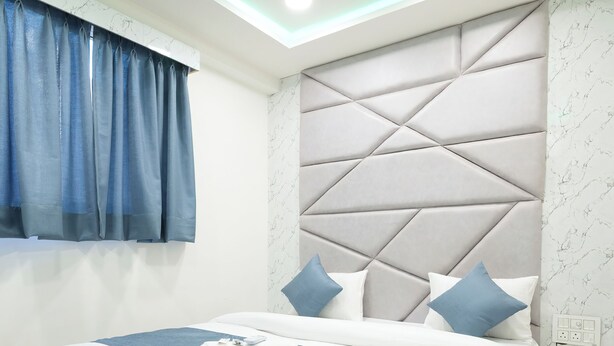 Een moderne slaapkamer met een groot bed, een plafondventilator en een hoofdeinde met een marmerlook.