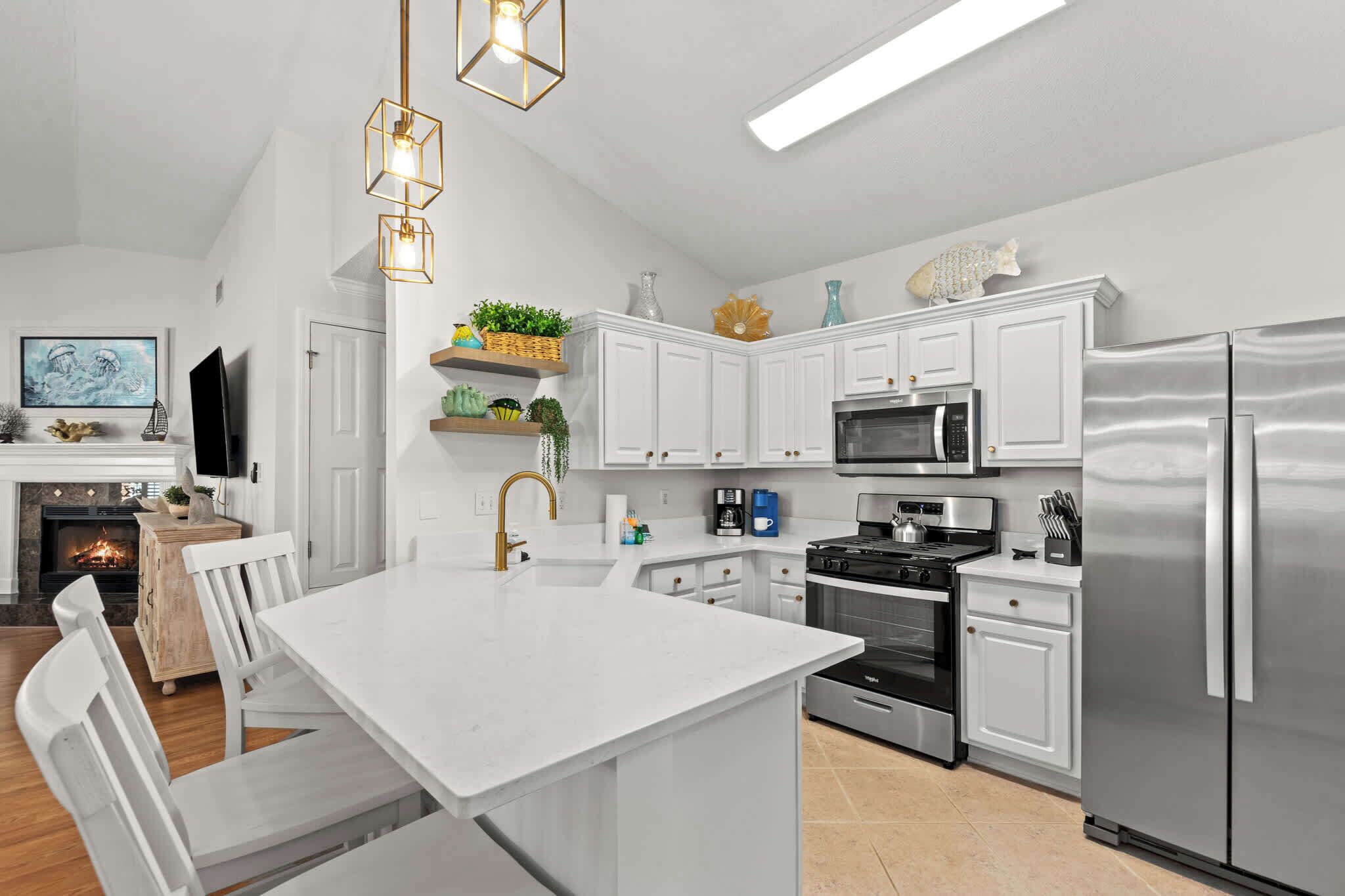 A modern kitchen with white cabinetry, stainless steel appliances, and a central island.